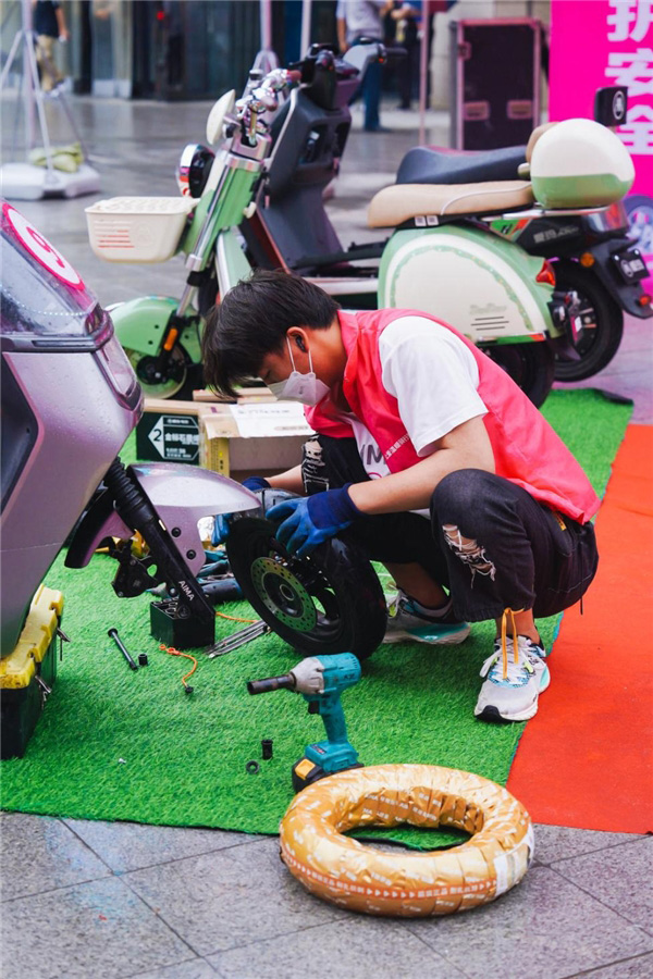 爱玛车服“轮胎节”活动中工作人员为用户提供轮胎相关服务
